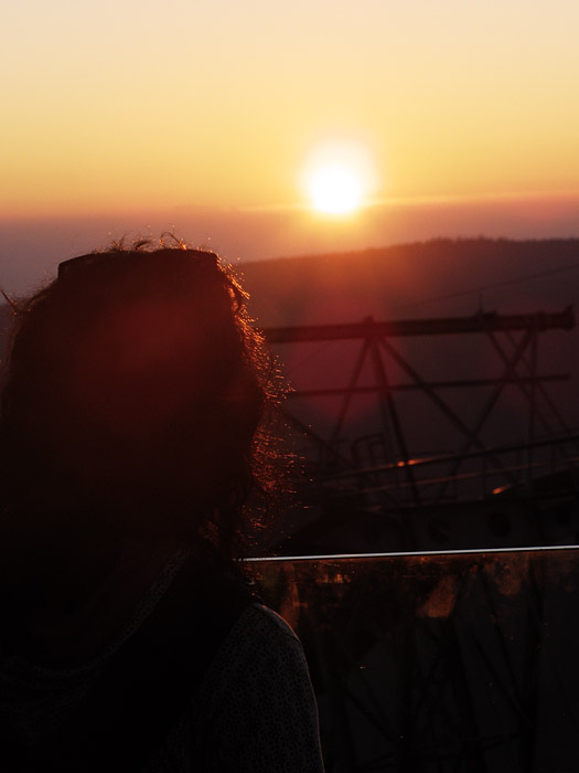 Girl in front of the sunset with lens flare